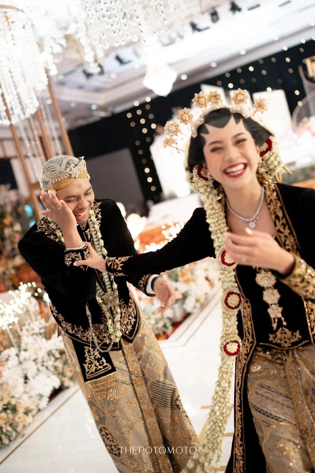 Risa dan Dandy tertawa dalam busana adat beludru hitam